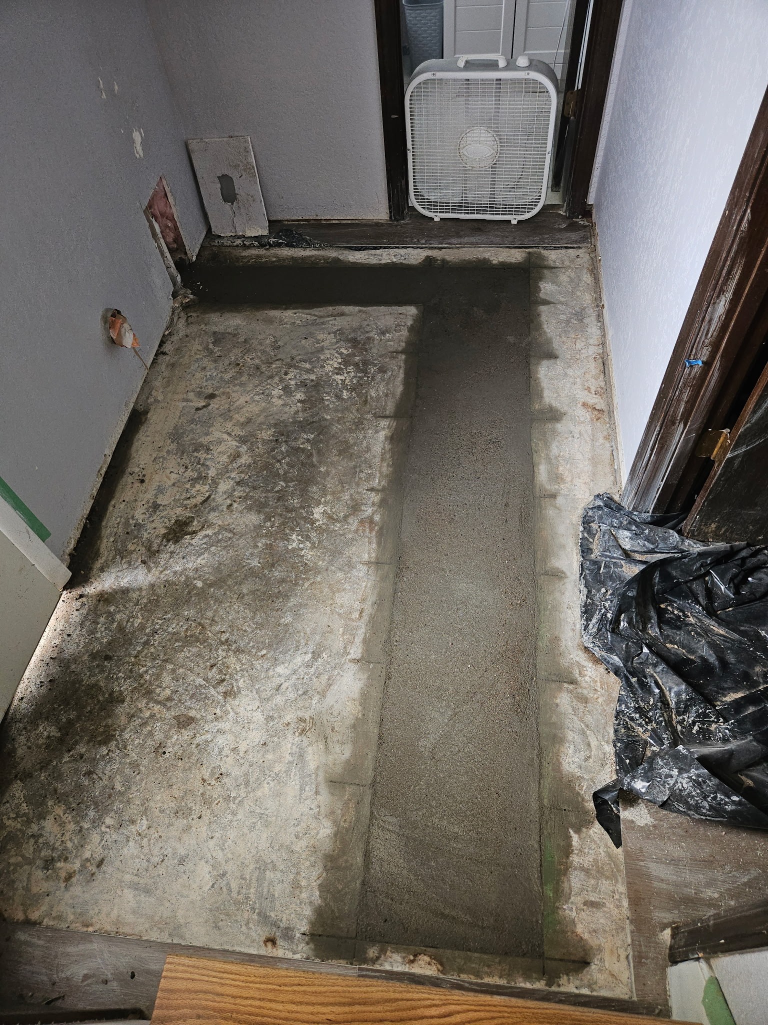 Fresh concrete restoring the floor above a repaired drain line